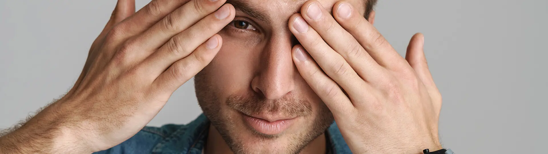 Mann mit gereizten Augen bei der Bildschirmarbeit